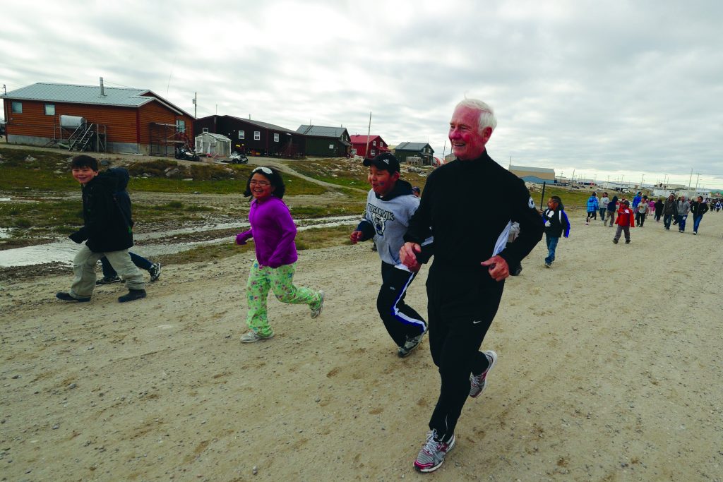 The Right Honourable David Johnston runs with children during an official visit to Repulse Bay, Nunavut, on Aug. 18, 2011. (Courtesy of the Rideau Hall Foundation)