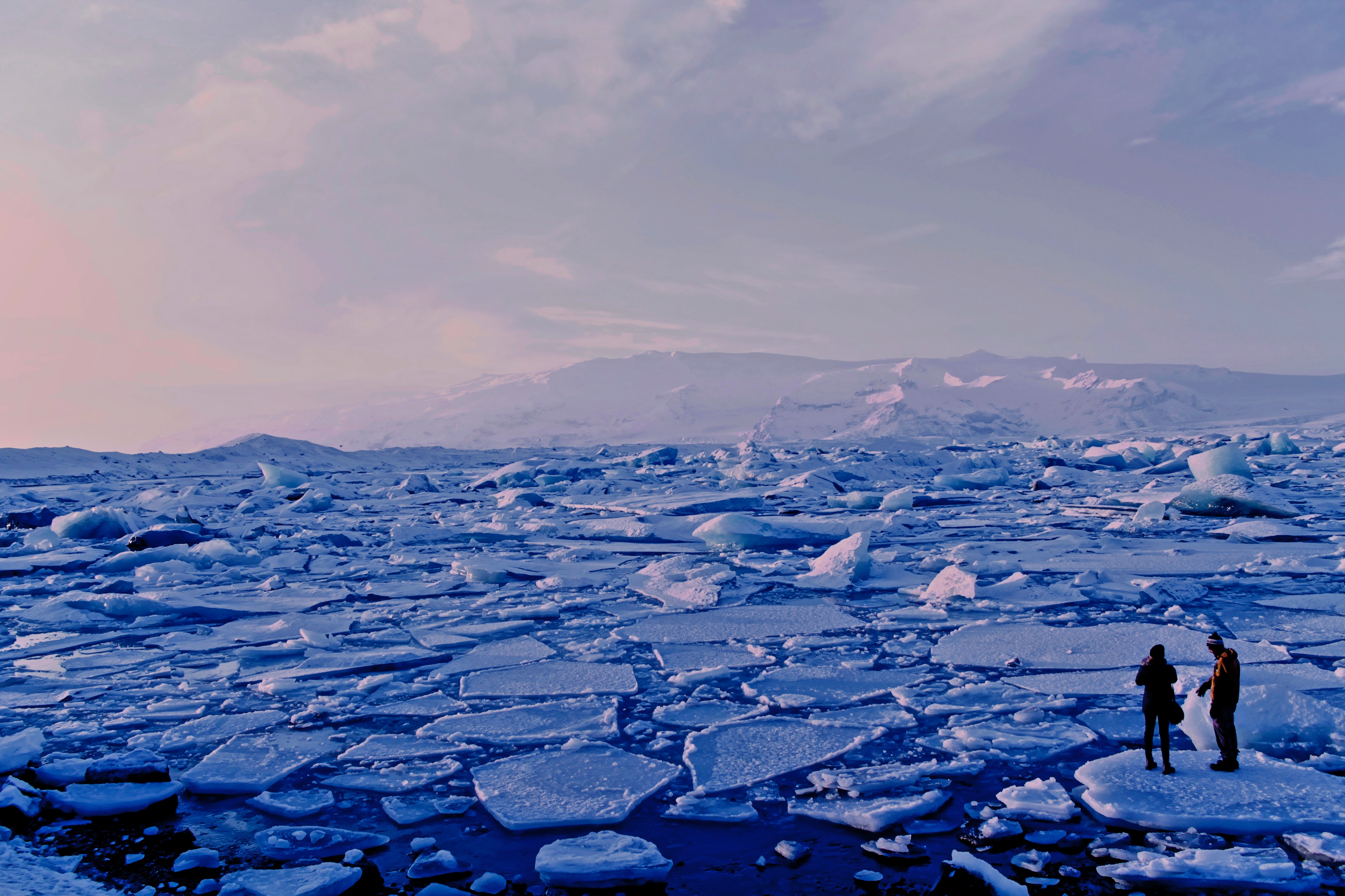 man and woman standing on broken ice in arctic