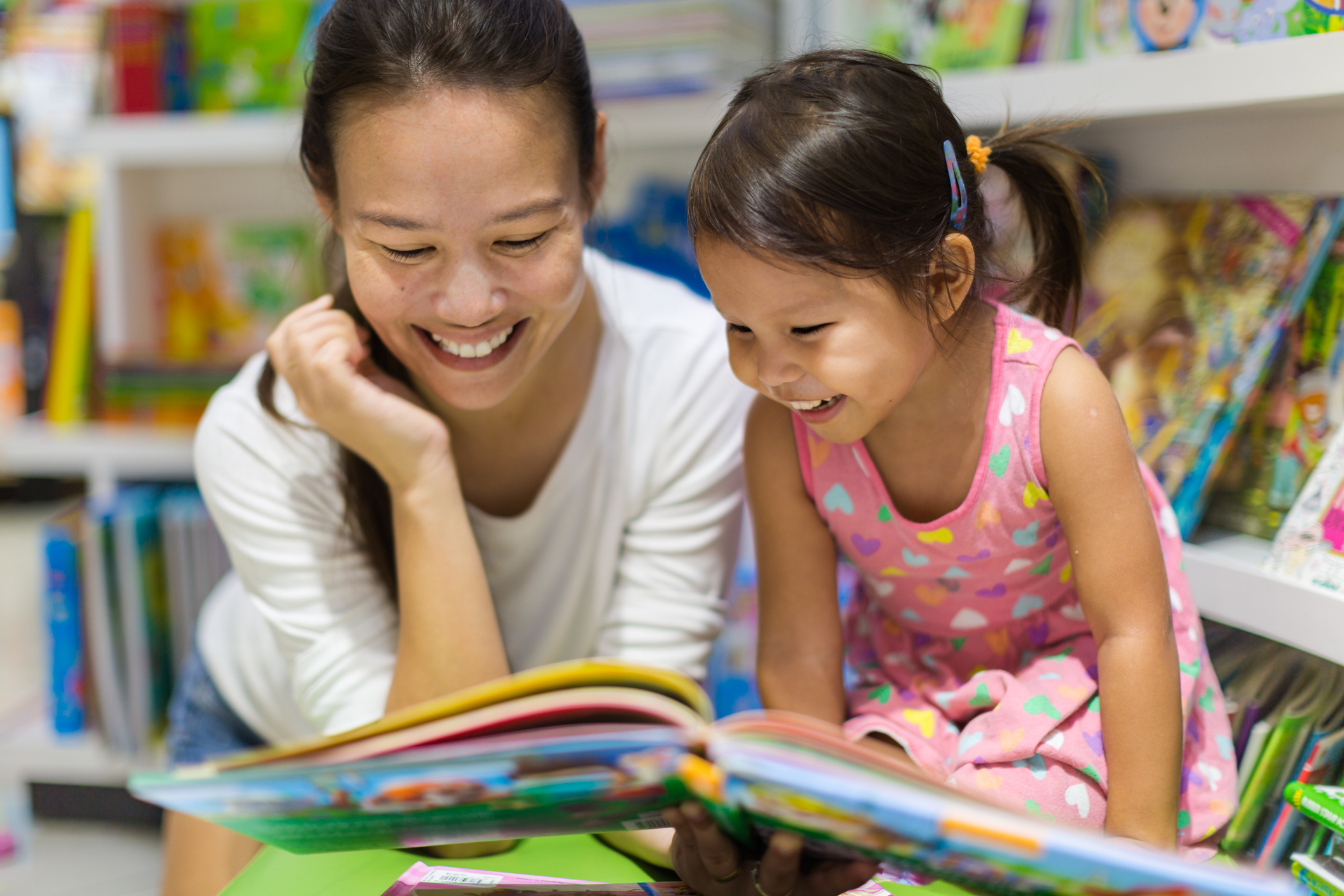 Parent And Child Reading Books Together In The Library Ceric