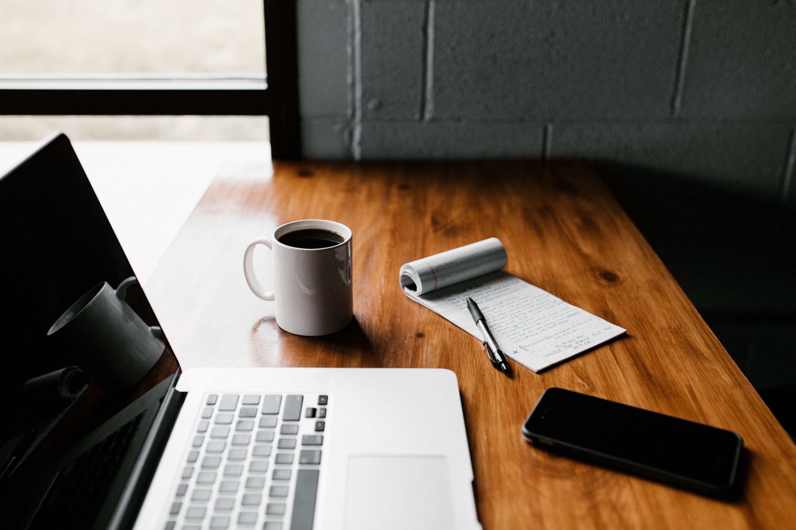 laptop, notebook and mug on desk