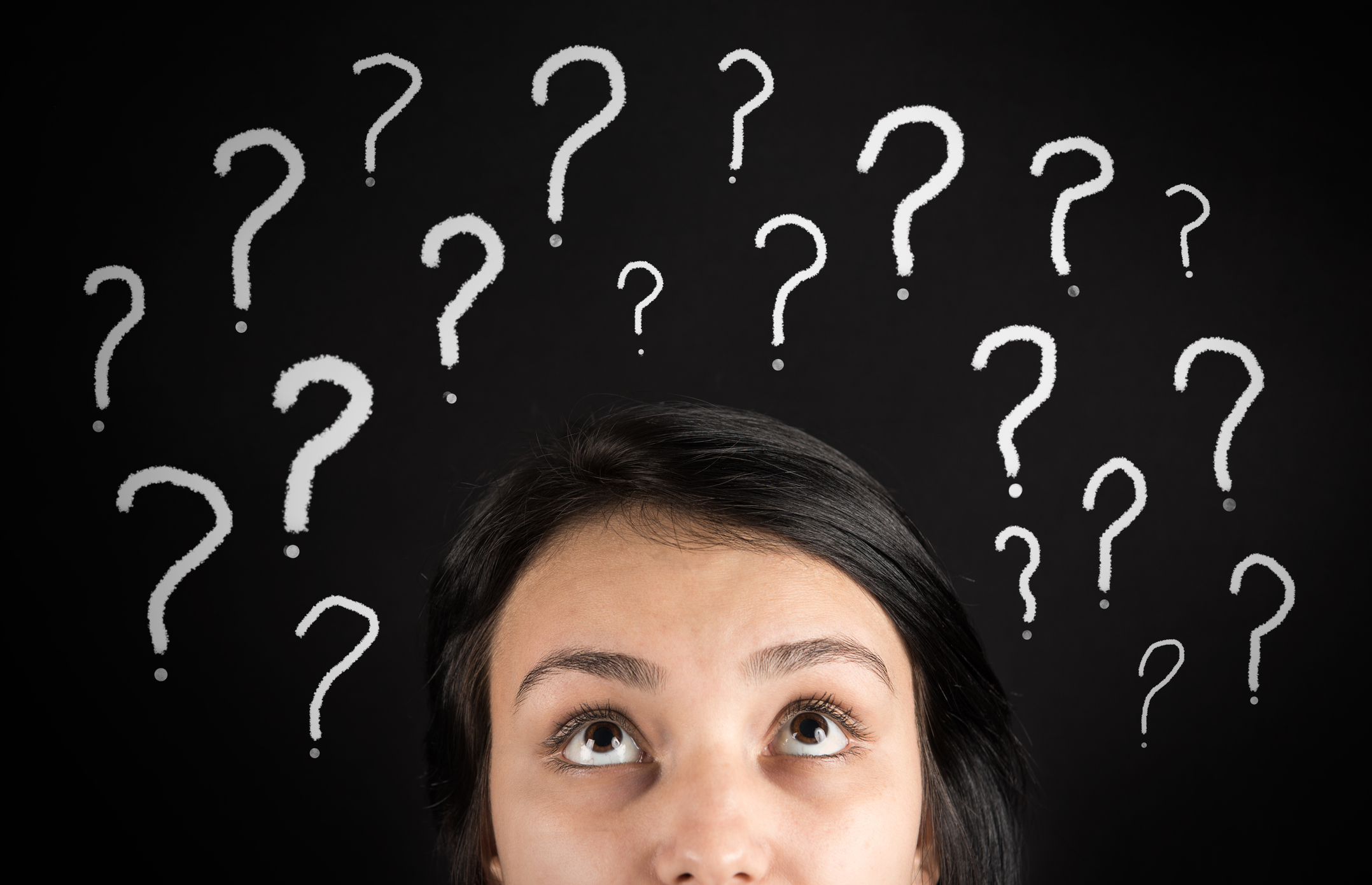confused woman looking up at question marks above head
