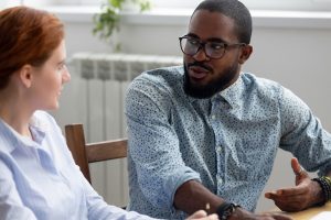 Diverse business people sitting at desk during meeting