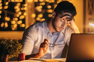 Frustrated man sitting at laptop