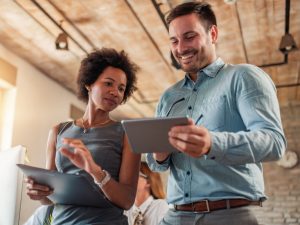 two people looking at tablet in office