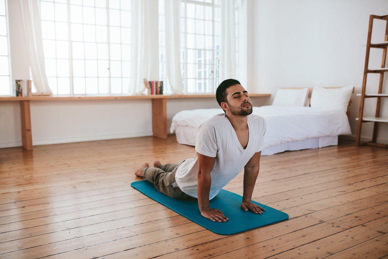 man doing yoga at home