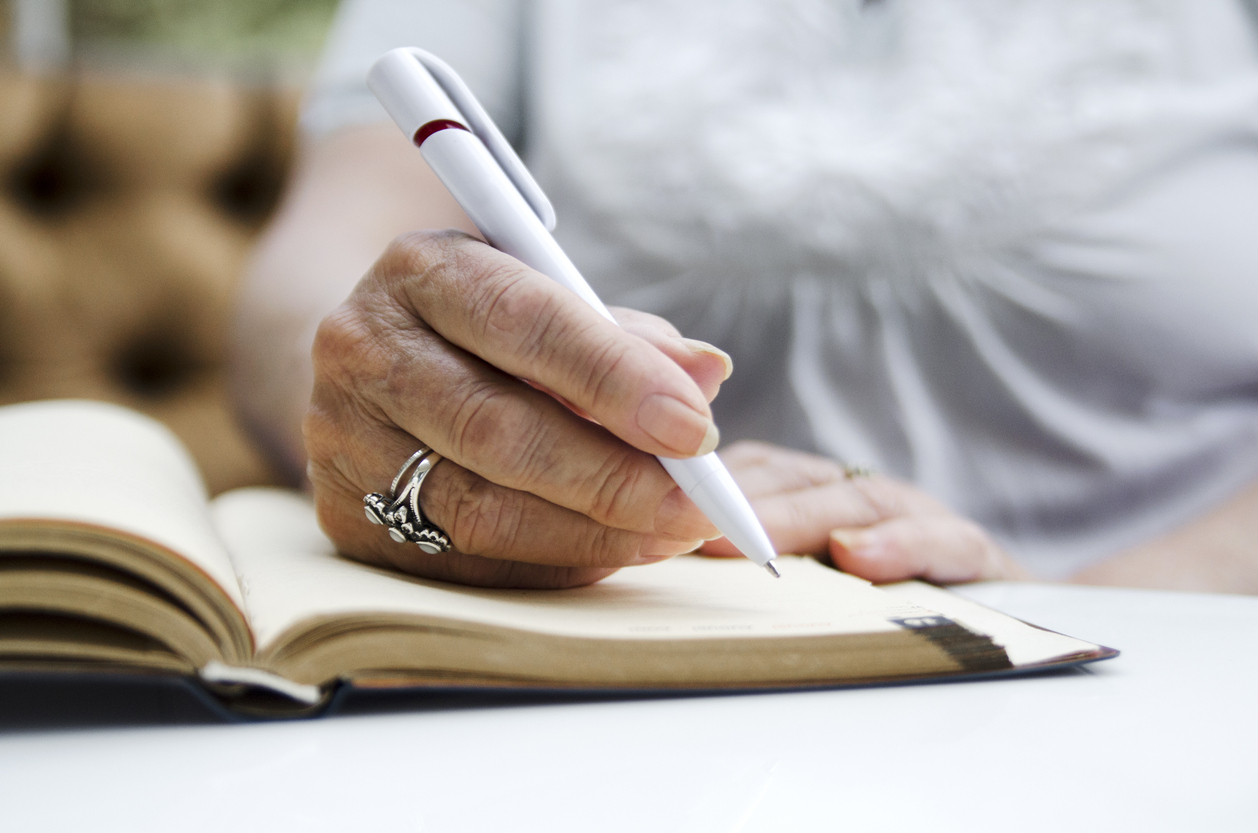 closeup of hands writing in notebook