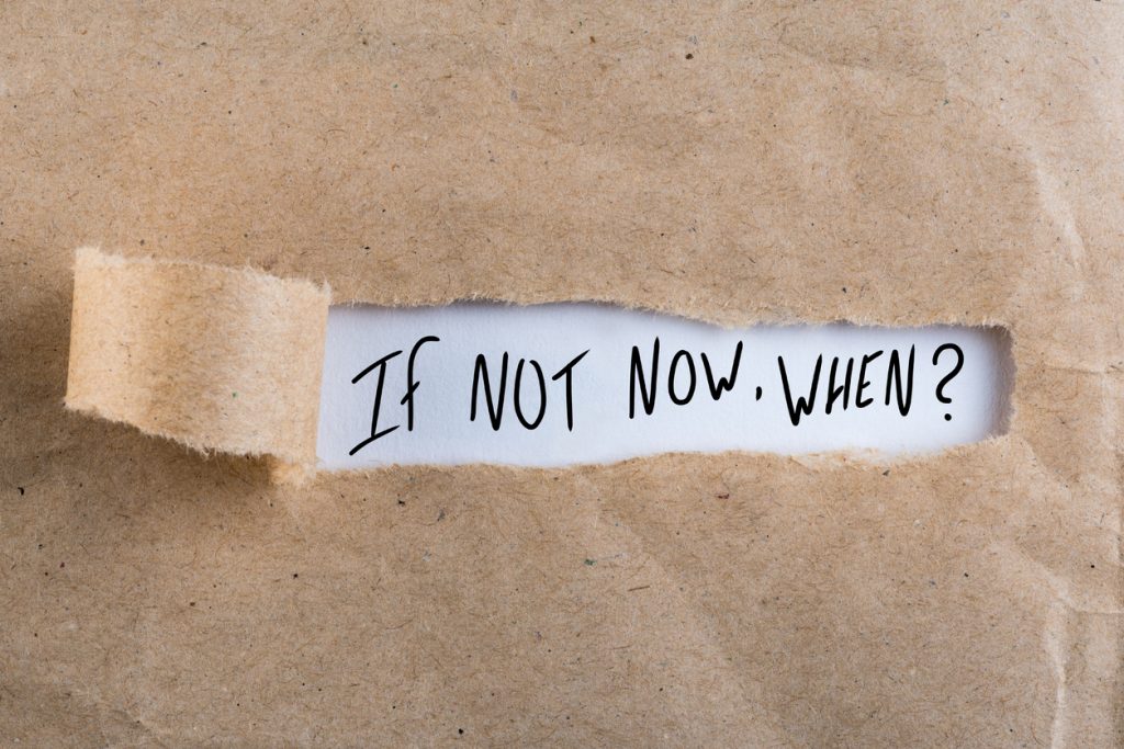 torn brown paper revealing words underneath "if not now, when?"