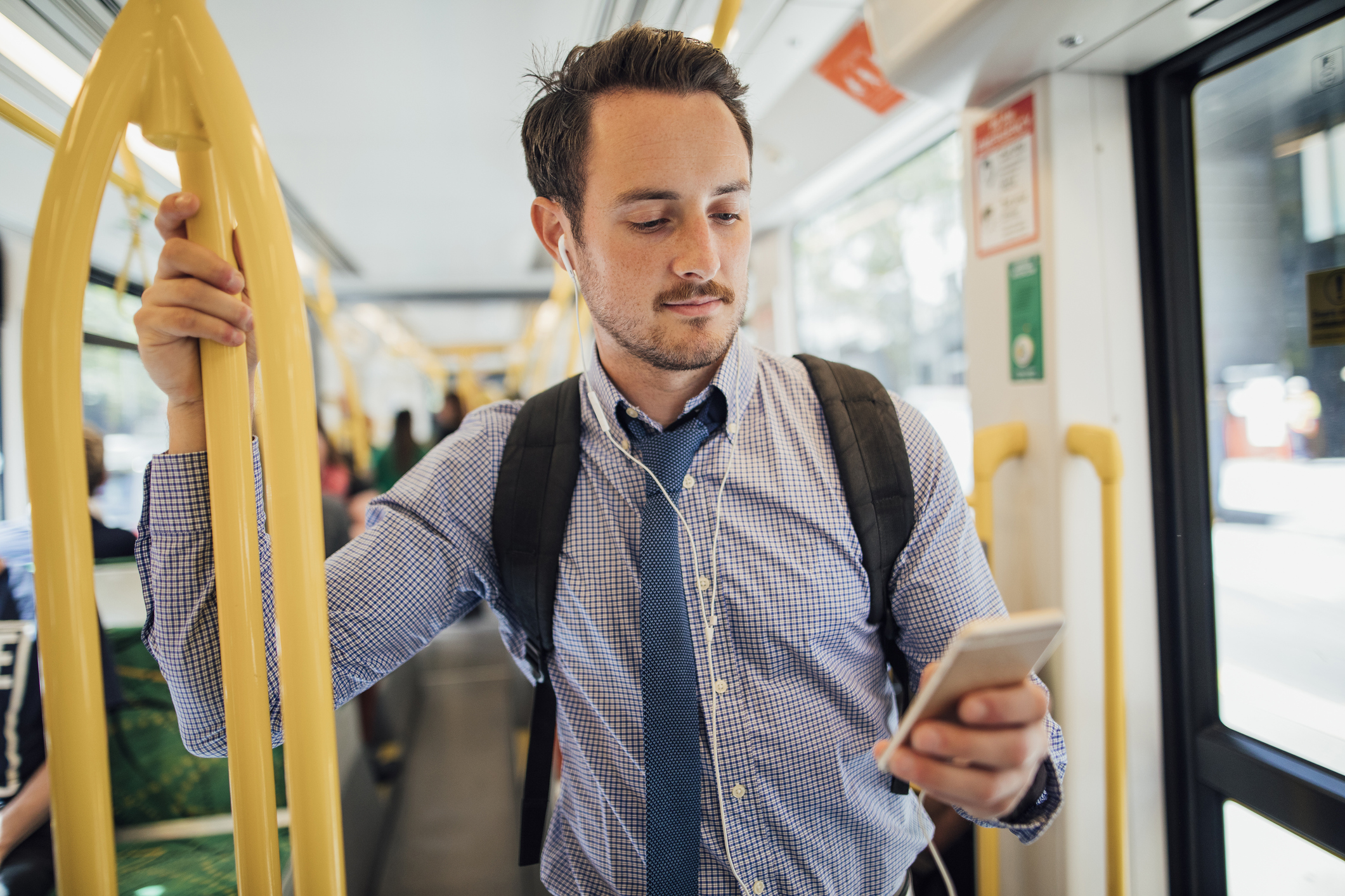 man wearing backpack on streetcar