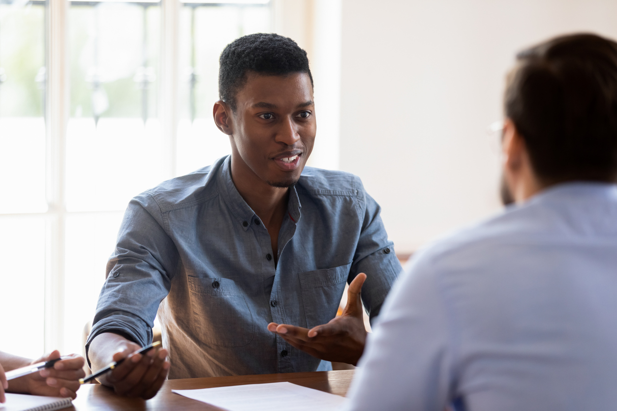 two men talking across table in office