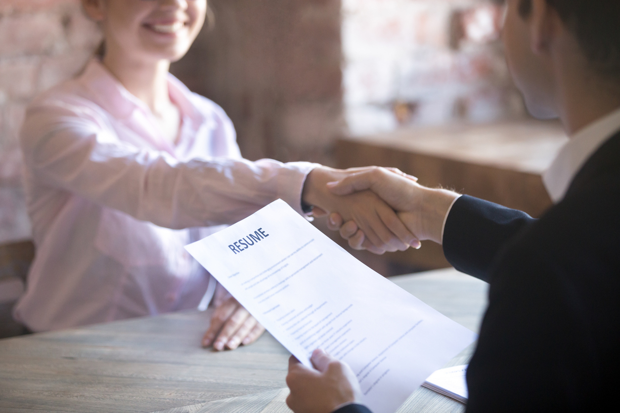 Smiling young woman and man handshake.