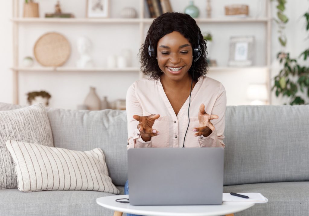 black woman having video call while sitting on couch