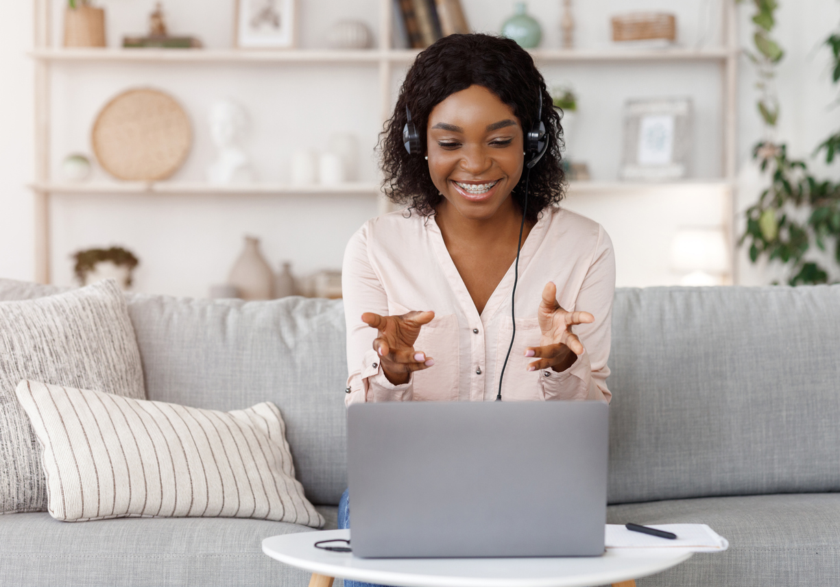black woman having video call while sitting on couch