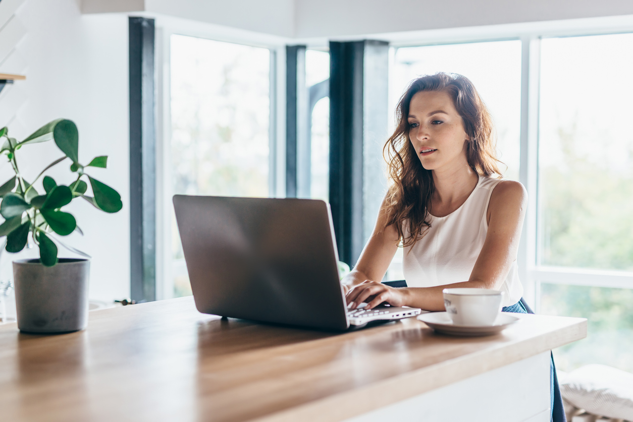 woman working on laptop on kitchen table