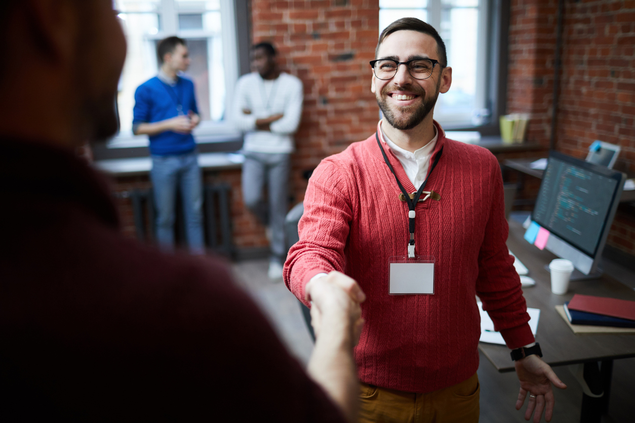 Man shaking hands with other person in office.