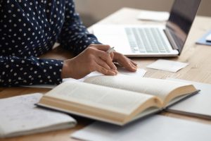 Close up of female student read book preparing for exam