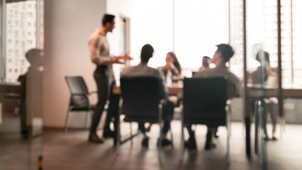 Blurred photo of people in boardroom meeting