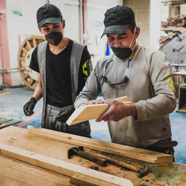 Carpenter and apprentice in workshop
