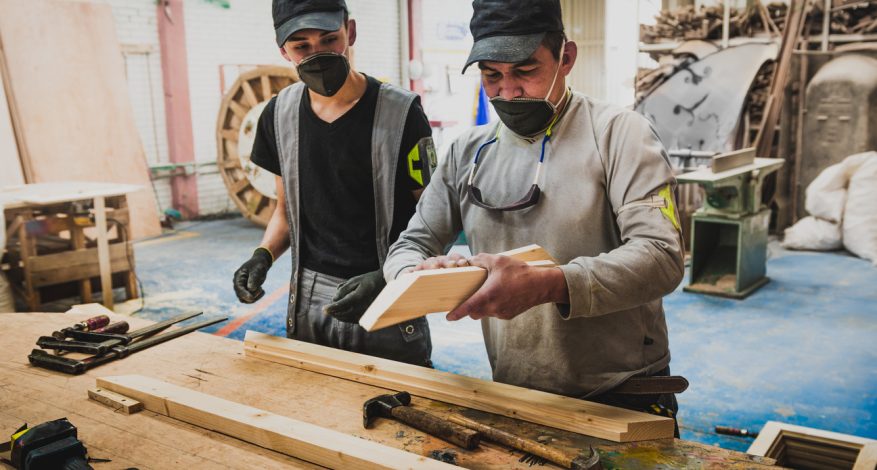 Carpenter and apprentice in workshop