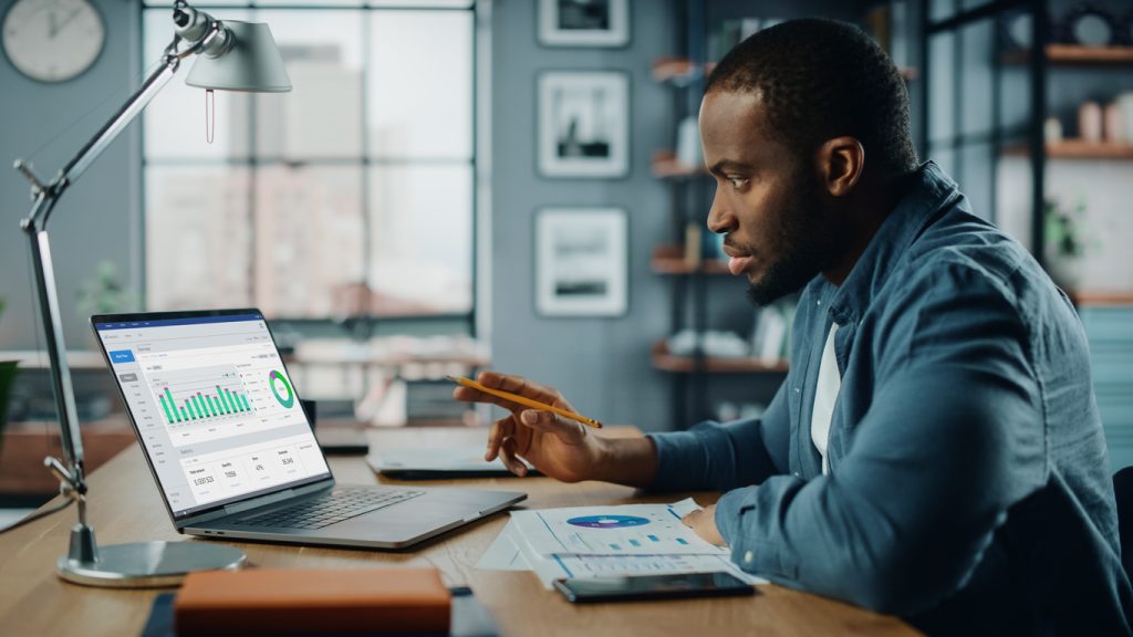 Black man working on laptop in home office