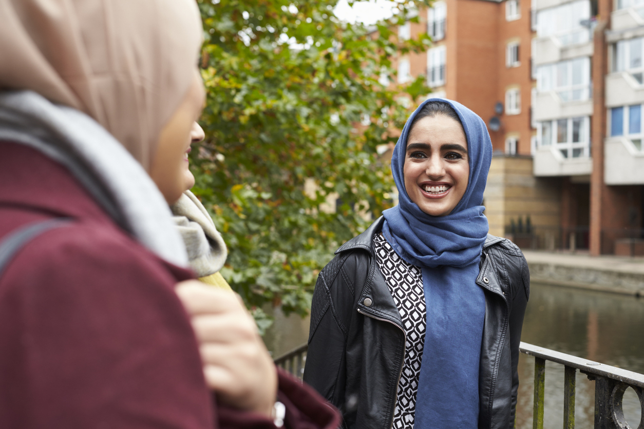 Three Muslim women talking outside