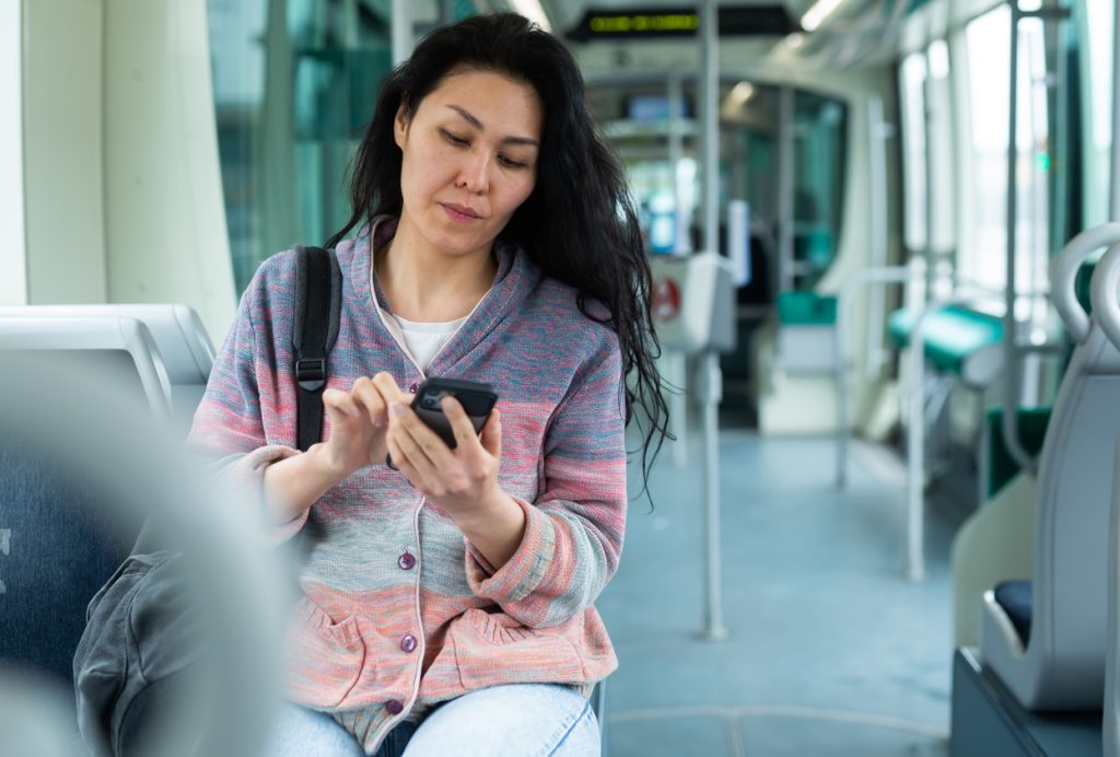 Woman texting while sitting on city bus