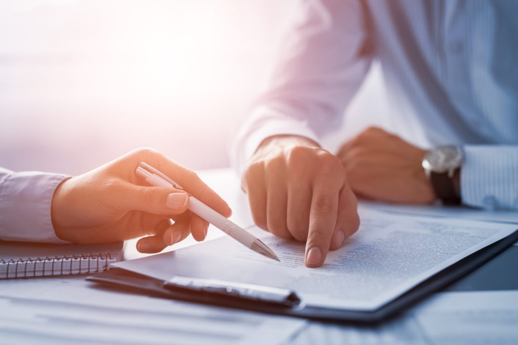 Close up of hands of two people looking at document