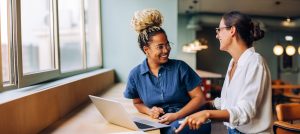 Two women smiling and talking in office